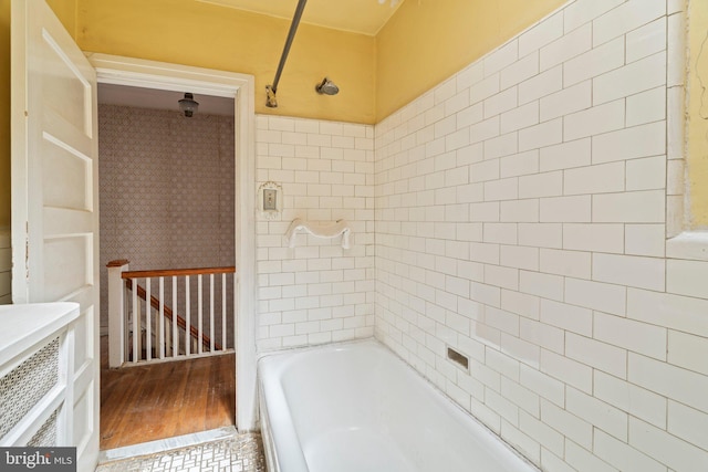full bath featuring wood finished floors and bathtub / shower combination