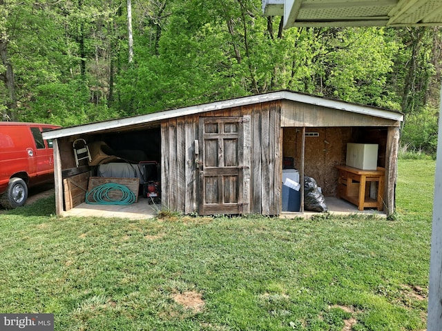view of outdoor structure featuring a view of trees and an outdoor structure
