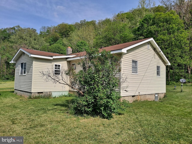view of property exterior featuring a lawn and crawl space