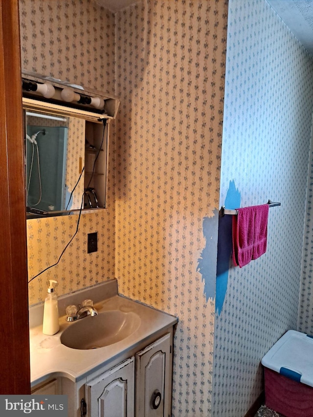 bathroom featuring vanity and wallpapered walls