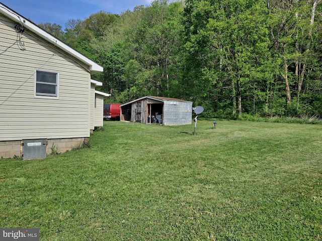 view of yard with a wooded view and an outdoor structure