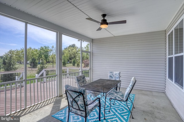 sunroom / solarium featuring outdoor dining area and ceiling fan
