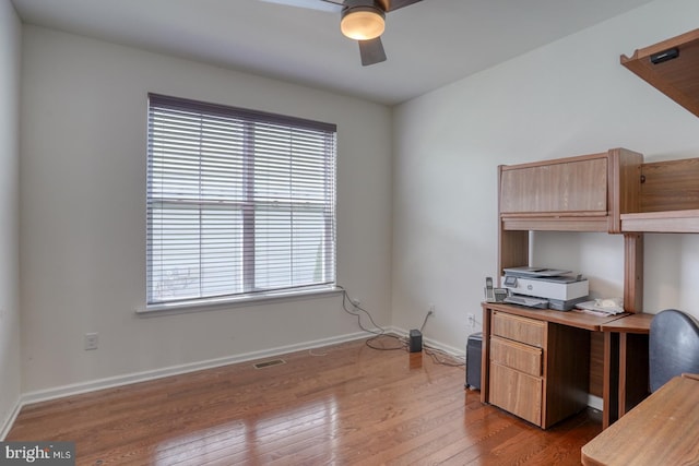 office space featuring baseboards, ceiling fan, wood-type flooring, and visible vents
