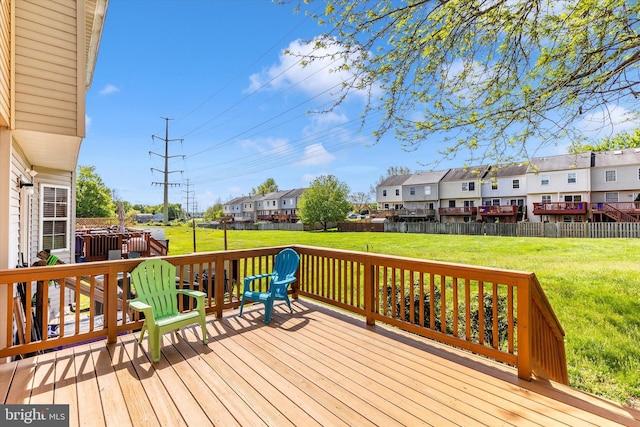 wooden deck featuring a yard, a residential view, and a fenced backyard