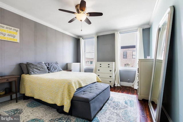bedroom featuring baseboards, ornamental molding, ceiling fan, and wood finished floors