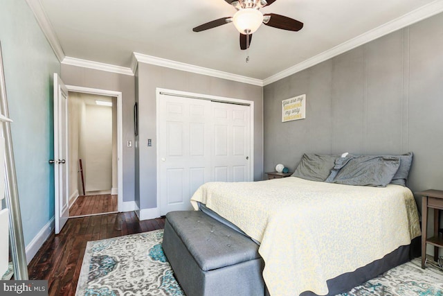 bedroom with crown molding, ceiling fan, hardwood / wood-style floors, baseboards, and a closet