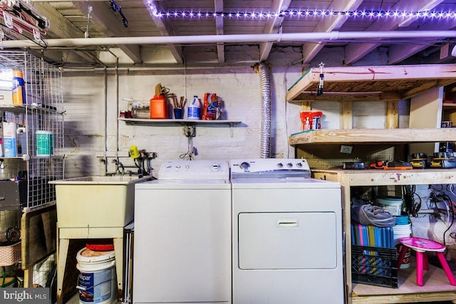washroom with laundry area, a sink, and independent washer and dryer