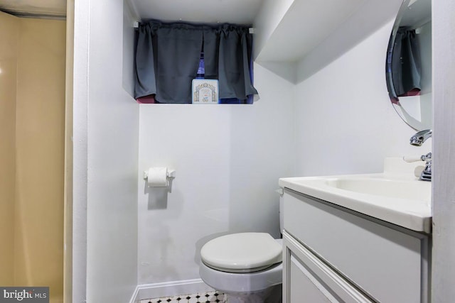 half bathroom featuring vanity, baseboards, and toilet