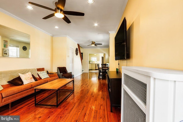 living room featuring wood-type flooring, recessed lighting, ceiling fan, and ornamental molding