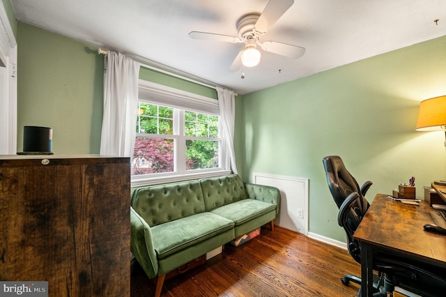 home office with a ceiling fan, baseboards, and wood finished floors