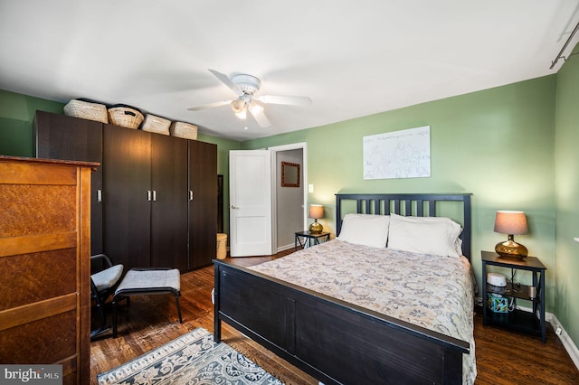 bedroom with baseboards, ceiling fan, and dark wood-style floors