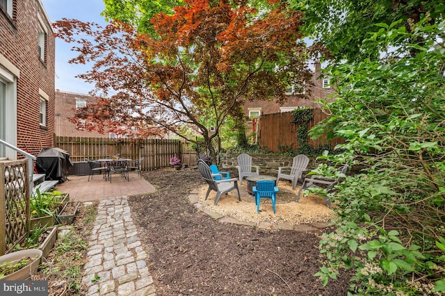 view of patio / terrace with a fire pit, a fenced backyard, and a grill