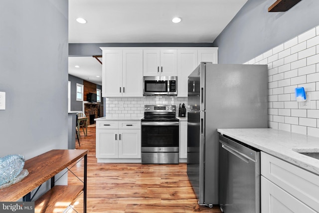 5310 Brabant Rd, Baltimore, MD 21229 - kitchen with stainless steel appliances, decorative backsplash, white cabinetry, light wood-style flooring, and recessed lighting