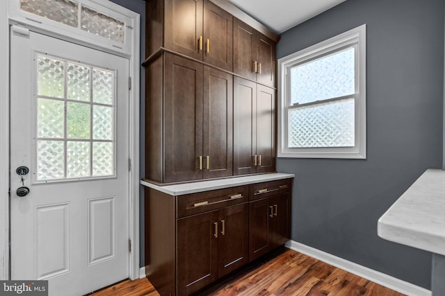 interior space with plenty of natural light, baseboards, and dark wood-type flooring