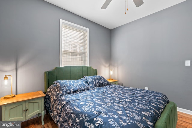 bedroom featuring a ceiling fan, baseboards, and wood finished floors