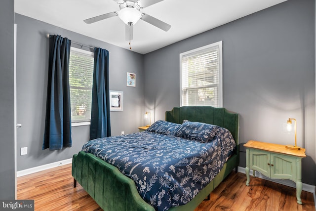 bedroom featuring a ceiling fan, baseboards, and wood finished floors