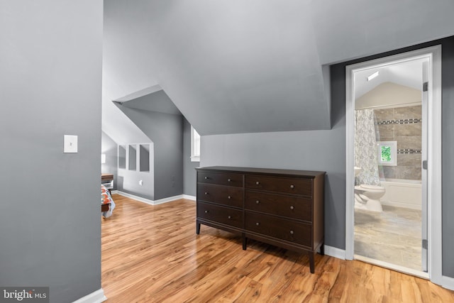 additional living space featuring baseboards, wood finished floors, and lofted ceiling