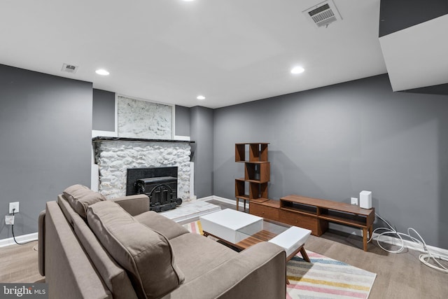 living room featuring recessed lighting, baseboards, visible vents, and wood finished floors