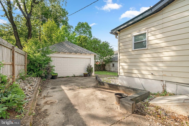 view of yard with a garage, fence, and an outdoor structure