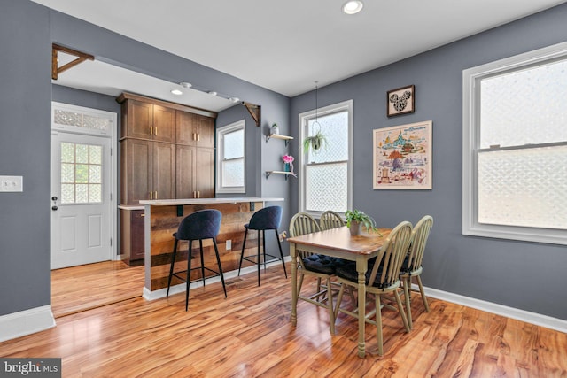 dining room with recessed lighting, baseboards, and light wood-type flooring