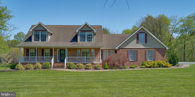 view of front of home with a porch, brick siding, and a front lawn