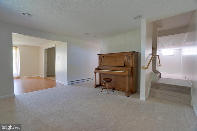 sitting room with a healthy amount of sunlight, baseboards, a baseboard heating unit, and stairs