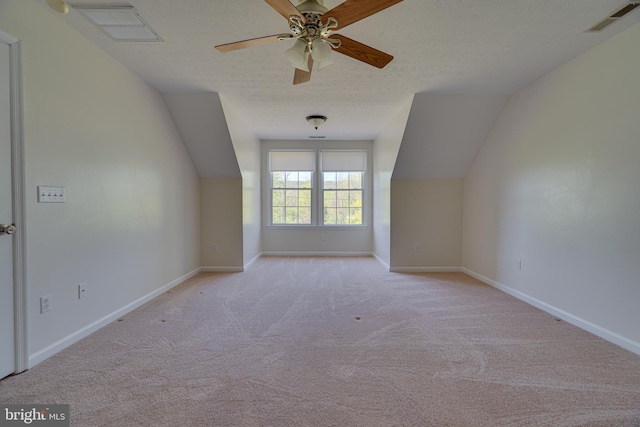 additional living space featuring carpet, vaulted ceiling, a textured ceiling, and visible vents