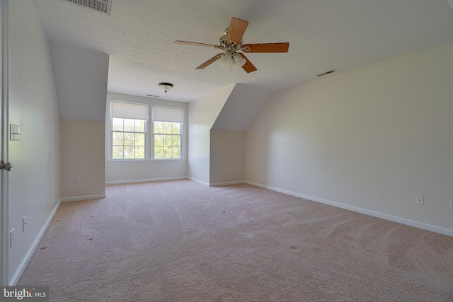 bonus room featuring visible vents, lofted ceiling, light carpet, baseboards, and ceiling fan