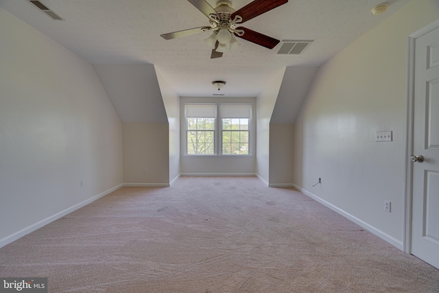 additional living space with ceiling fan, light colored carpet, and visible vents