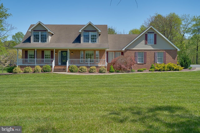 view of front of property featuring brick siding, a front lawn, and a porch