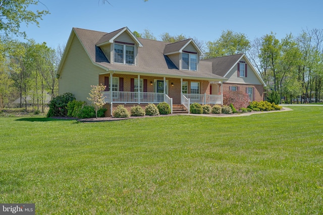 cape cod home featuring covered porch, brick siding, and a front lawn