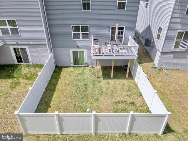 back of property featuring a yard, a wooden deck, a fenced backyard, and central AC unit