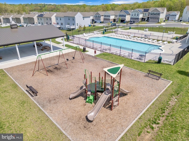 surrounding community with a residential view, fence, playground community, a lawn, and a swimming pool