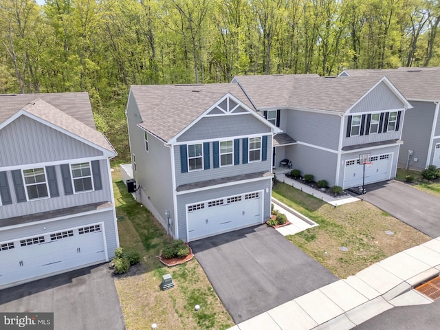 view of front of house with a shingled roof, an attached garage, cooling unit, and aphalt driveway