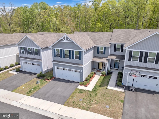 view of front facade featuring an attached garage, aphalt driveway, and roof with shingles