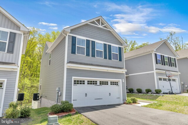 view of front of property featuring a garage, central AC, and driveway