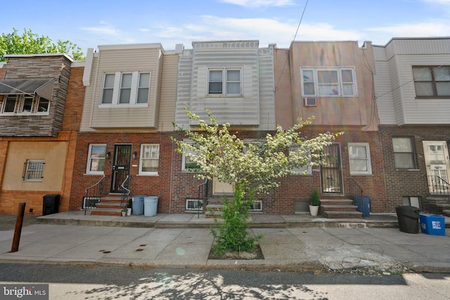 rear view of house featuring brick siding and entry steps
