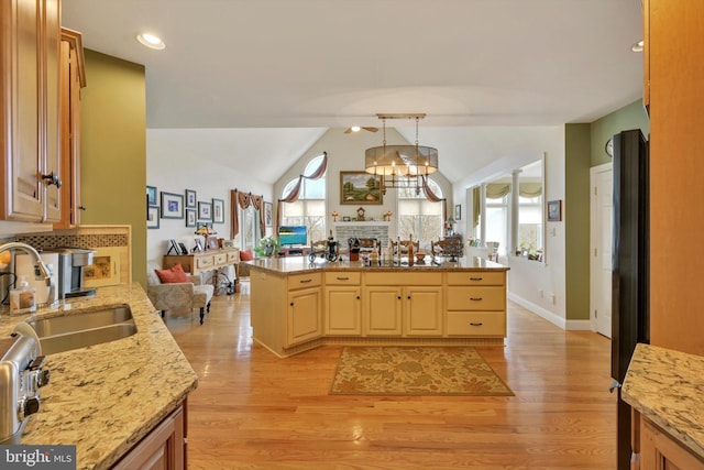 kitchen featuring a healthy amount of sunlight, a fireplace, open floor plan, and lofted ceiling
