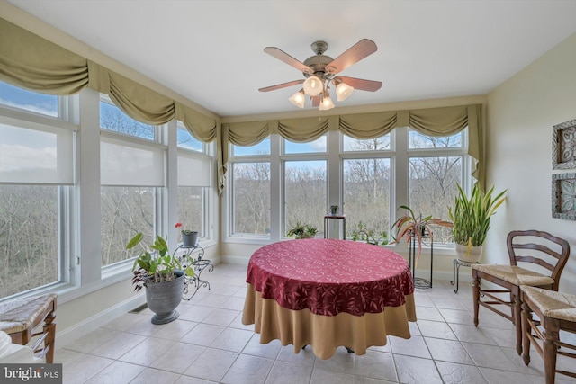 sunroom featuring baseboards, tile patterned flooring, and a healthy amount of sunlight