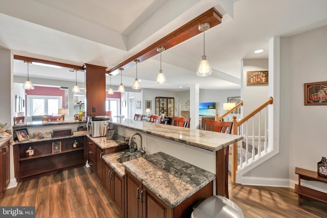 kitchen with decorative light fixtures, baseboards, dark wood finished floors, and a sink