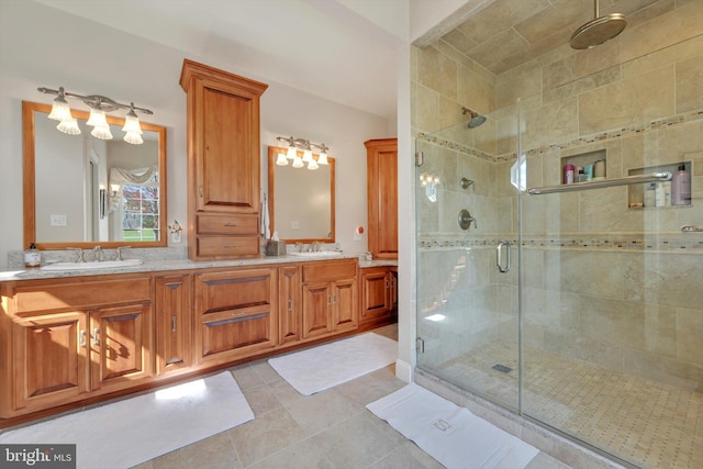 bathroom with a sink, tile patterned flooring, a stall shower, and double vanity