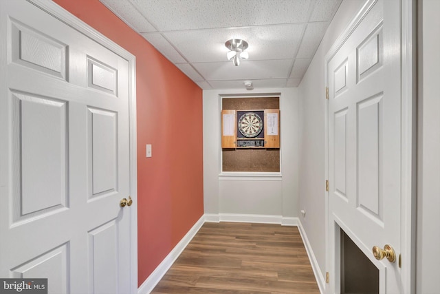 hall with baseboards, dark wood-type flooring, and a paneled ceiling