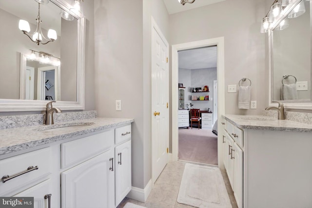 bathroom with a sink, tile patterned floors, two vanities, and a chandelier