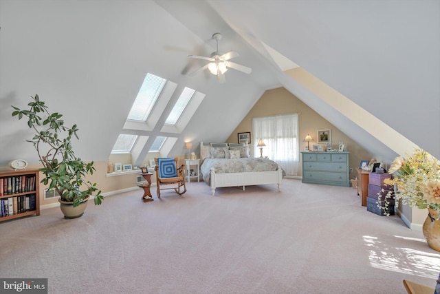 carpeted bedroom with baseboards and vaulted ceiling with skylight