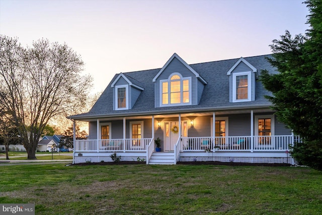view of front of house featuring roof with shingles, a yard, and covered porch