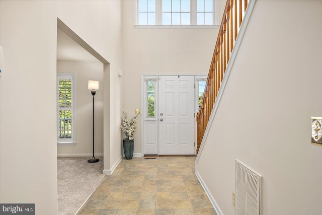 foyer with stairs, visible vents, and plenty of natural light