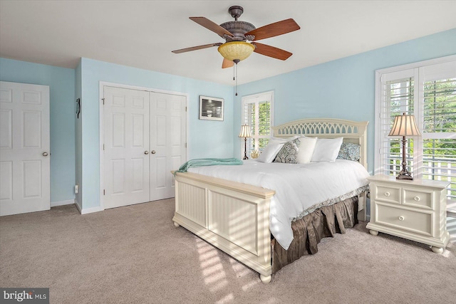 carpeted bedroom with baseboards, ceiling fan, and a closet