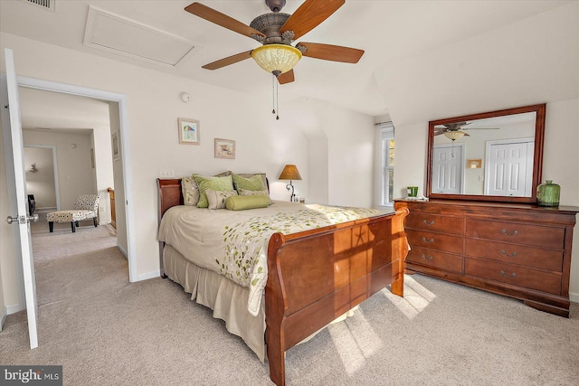 bedroom featuring ceiling fan, attic access, visible vents, and light colored carpet
