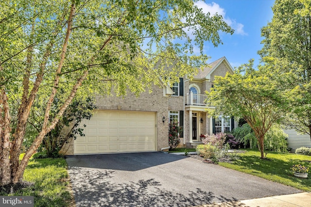 9743 Wyndham Dr, Frederick, MD 21704 - view of front of home with a balcony, asphalt driveway, brick siding, and a front yard