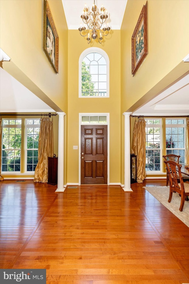 9743 Wyndham Dr, Frederick, MD 21704 - foyer featuring ornate columns, a chandelier, light wood finished floors, plenty of natural light, and a high ceiling